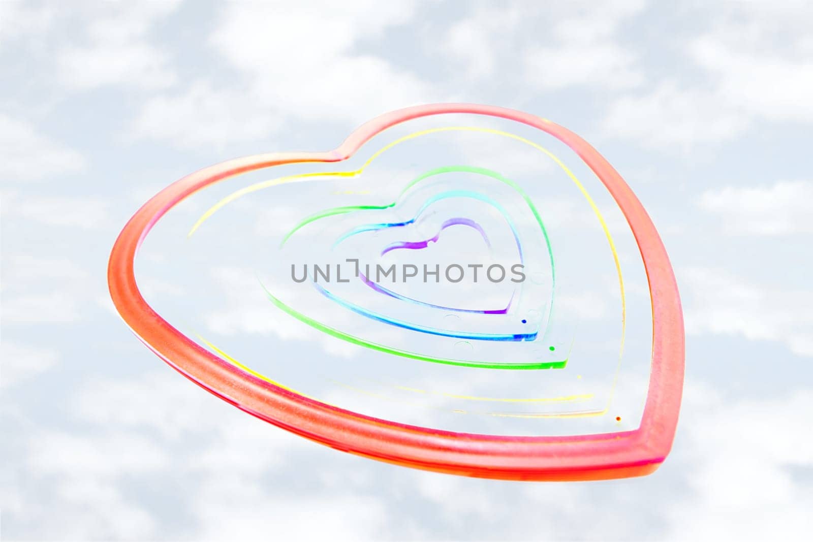 six heart shaped plastic pieces one inside the other on a cloudy background as if floating on air