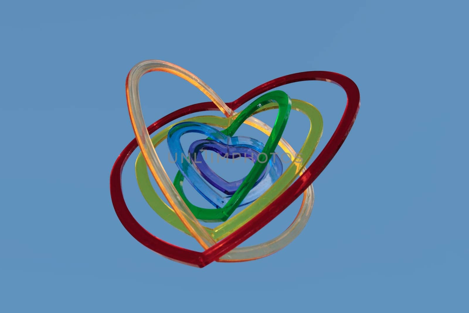 six heart shaped plastic pieces one inside the other on a blue background as if floating on air