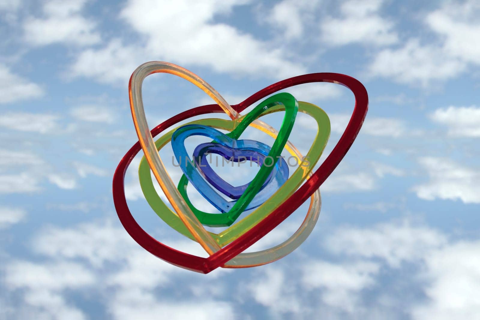 six heart shaped plastic pieces one inside the other on a cloudy background as if floating on air
