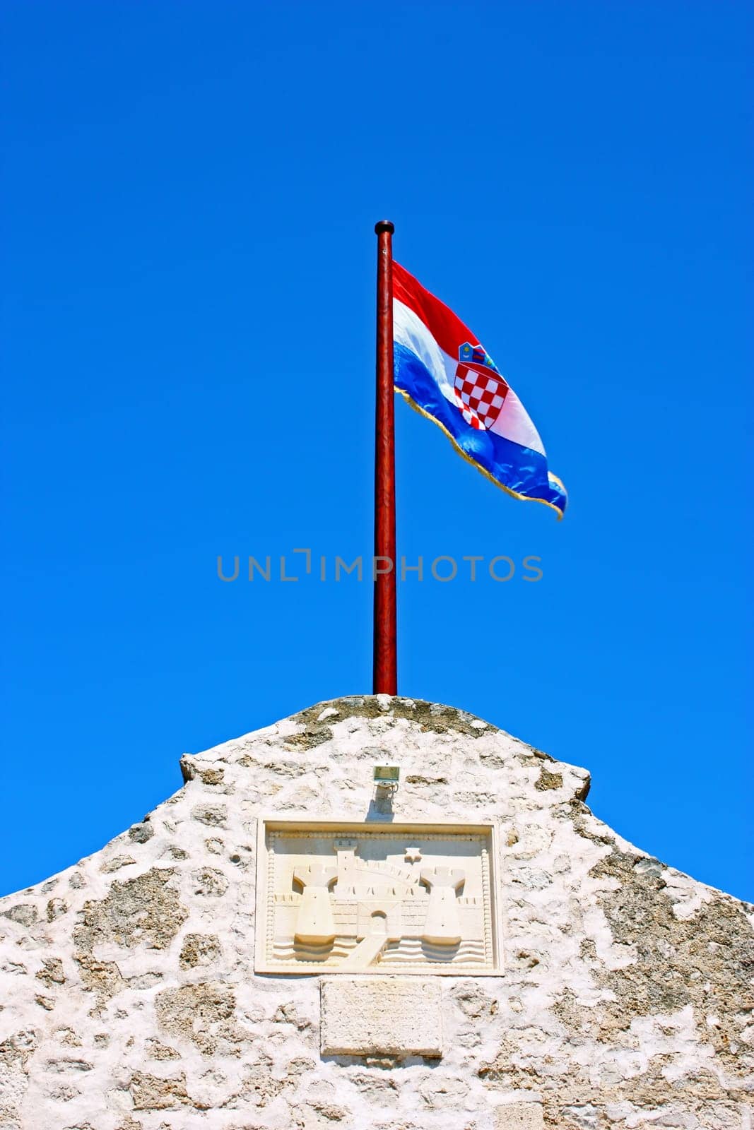 Croatian flag on the top of the wall at the entrance to the city Nin