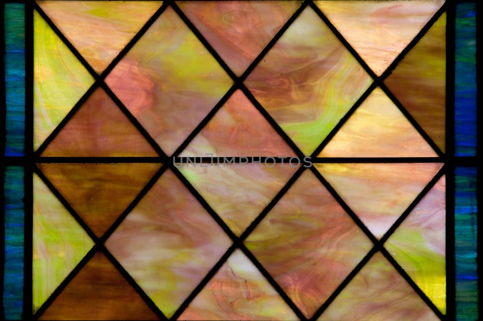 Stained glass window with diamond shapes and overall red brown color