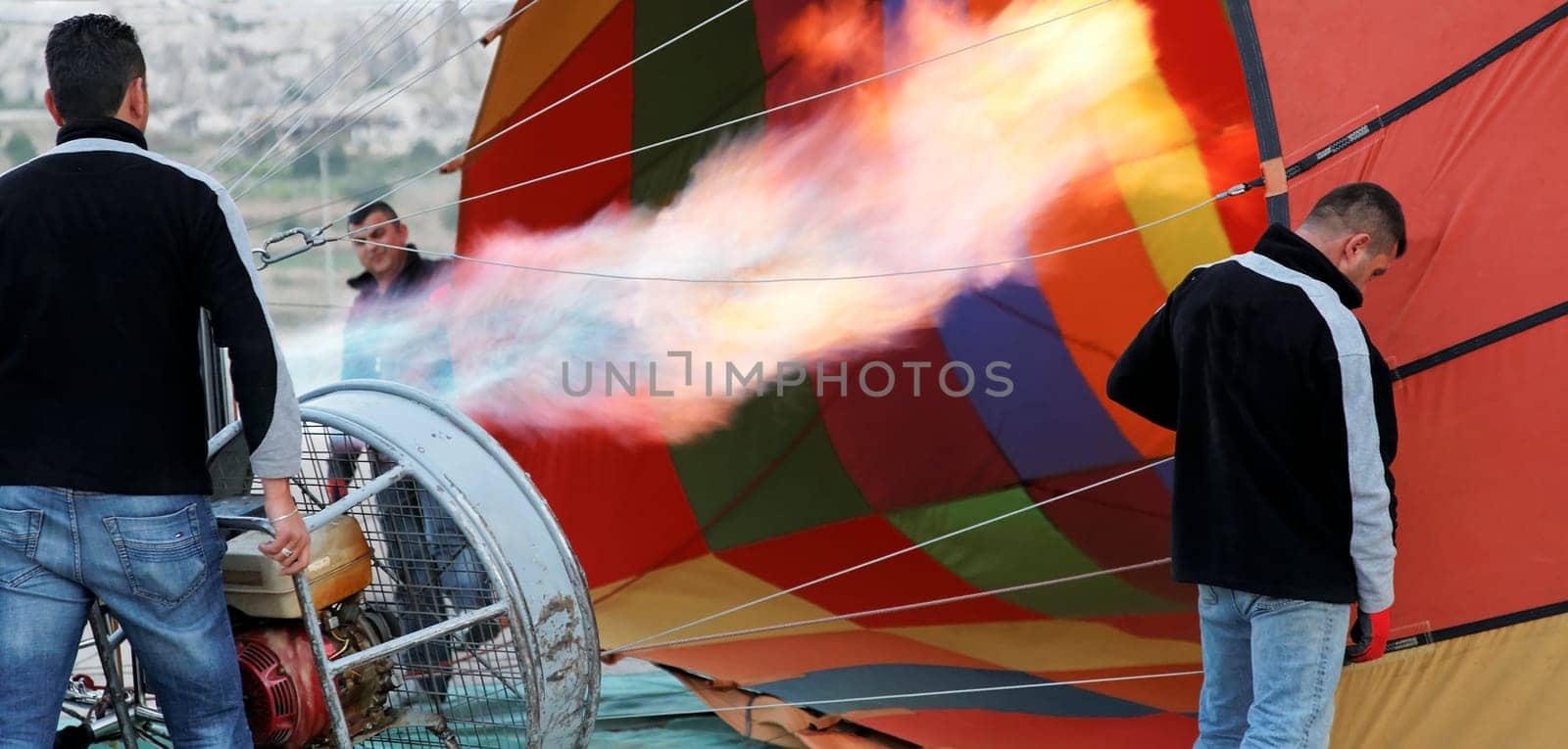 flames hot air balloon assistants getting balloon ready for next flight, multi colors, landscape, crop space and copy area