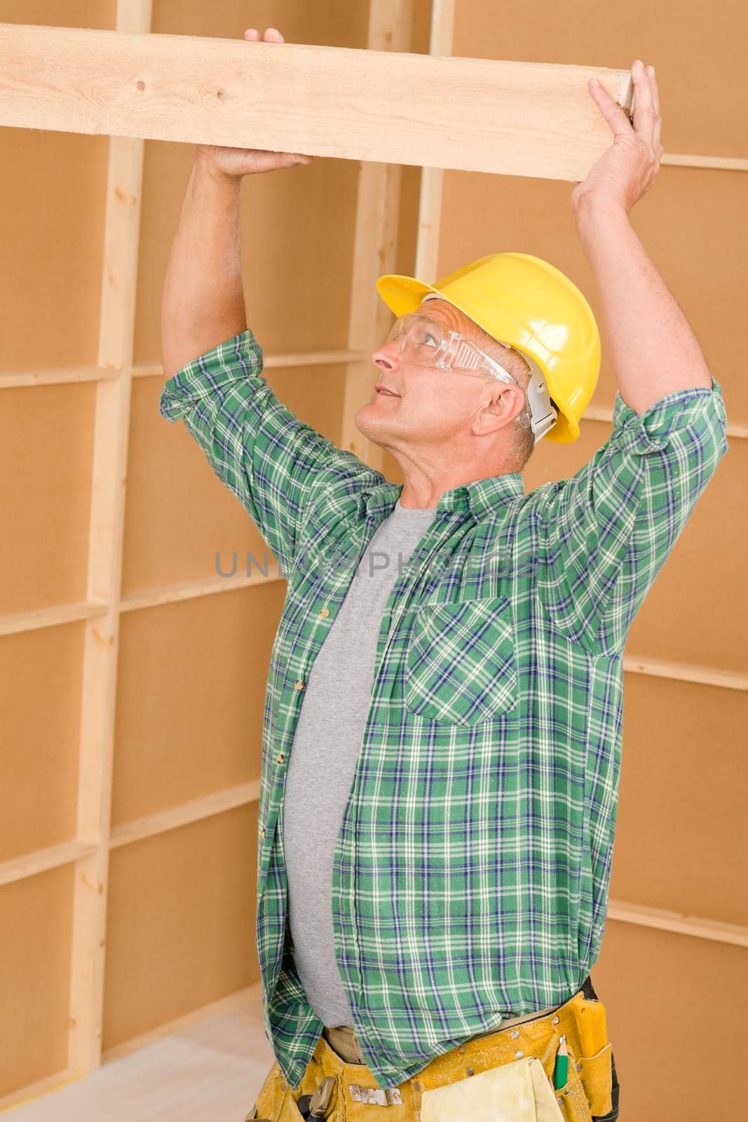 Handyman home improvement carpenter mature professional fitting wooden beam