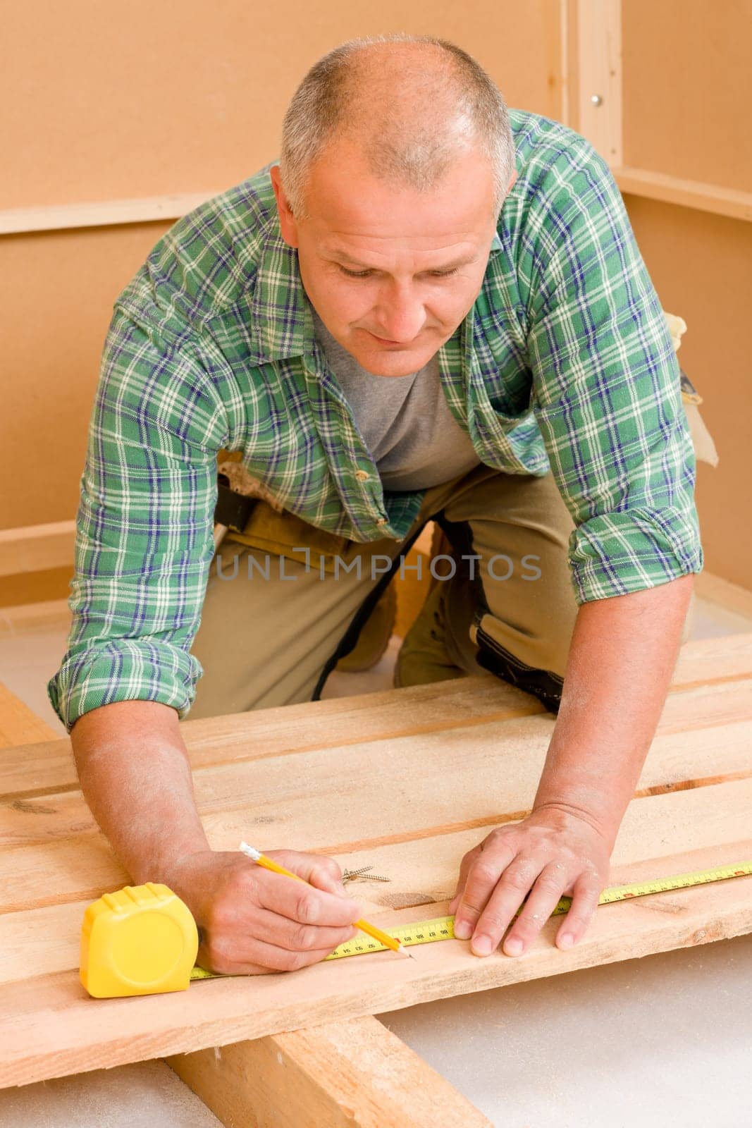 Mature handyman home improvement installing wooden floor in new house