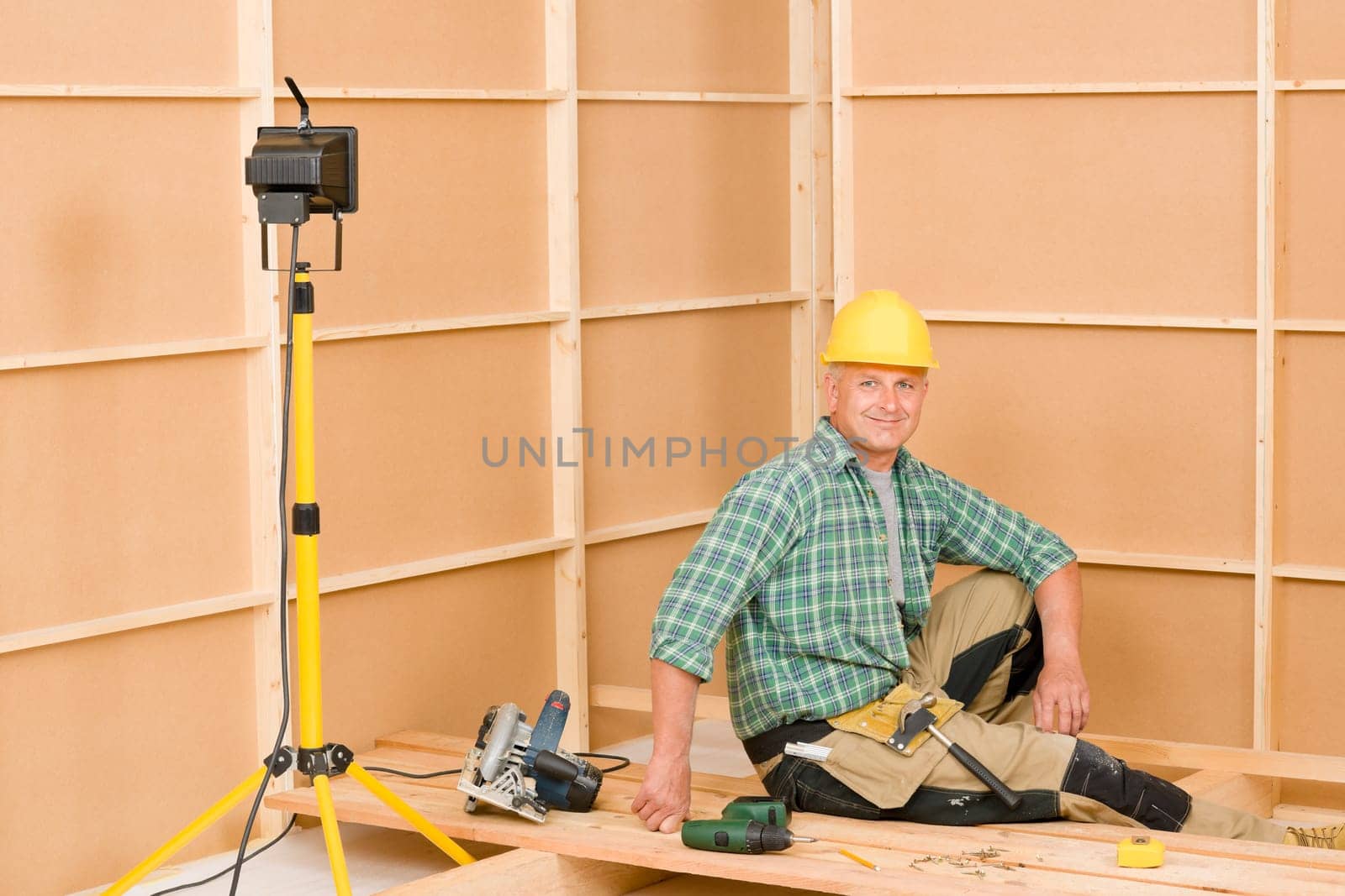 Mature handyman home improvement installing wooden floor in new house