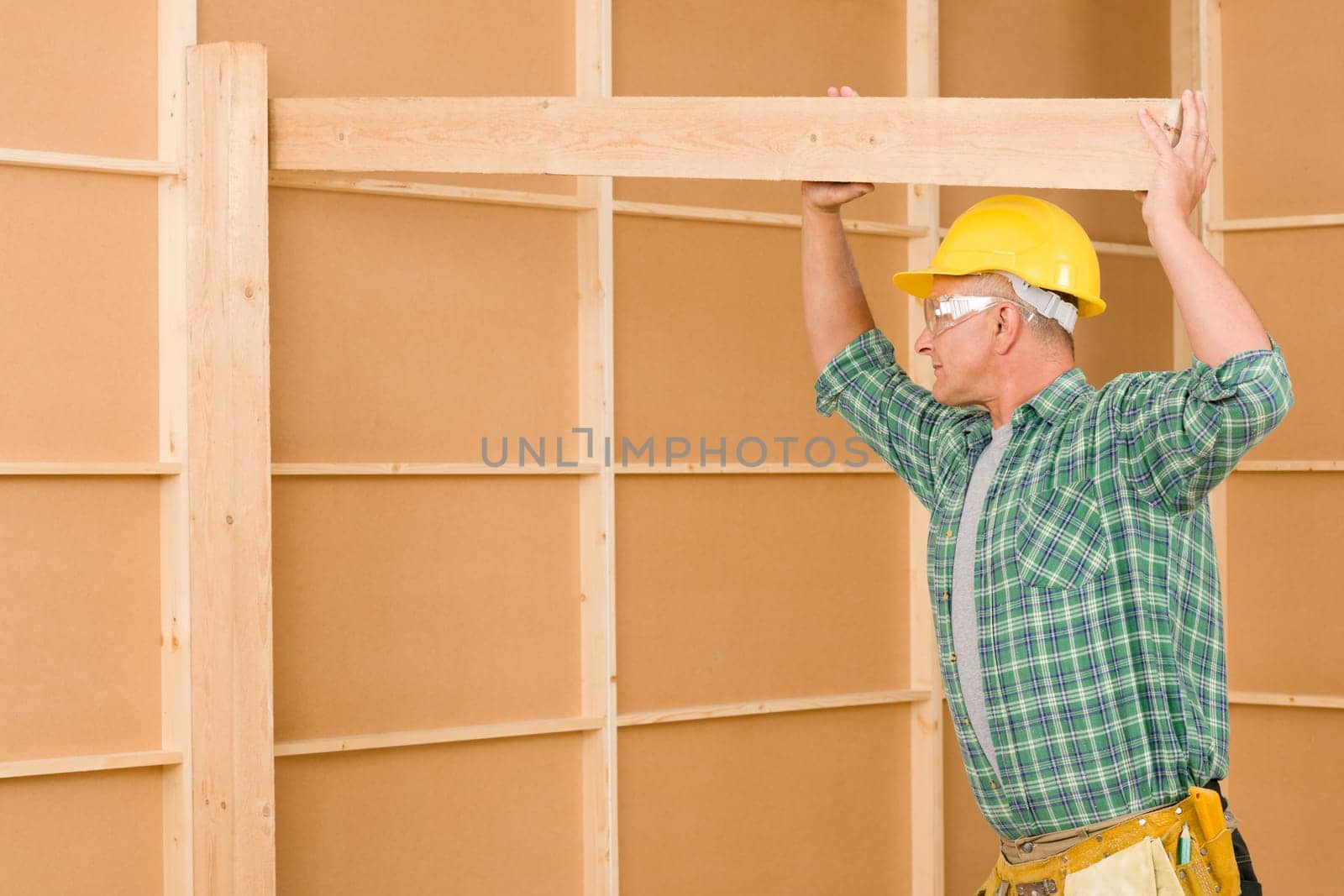 Handyman home improvement carpenter mature professional fitting wooden beam