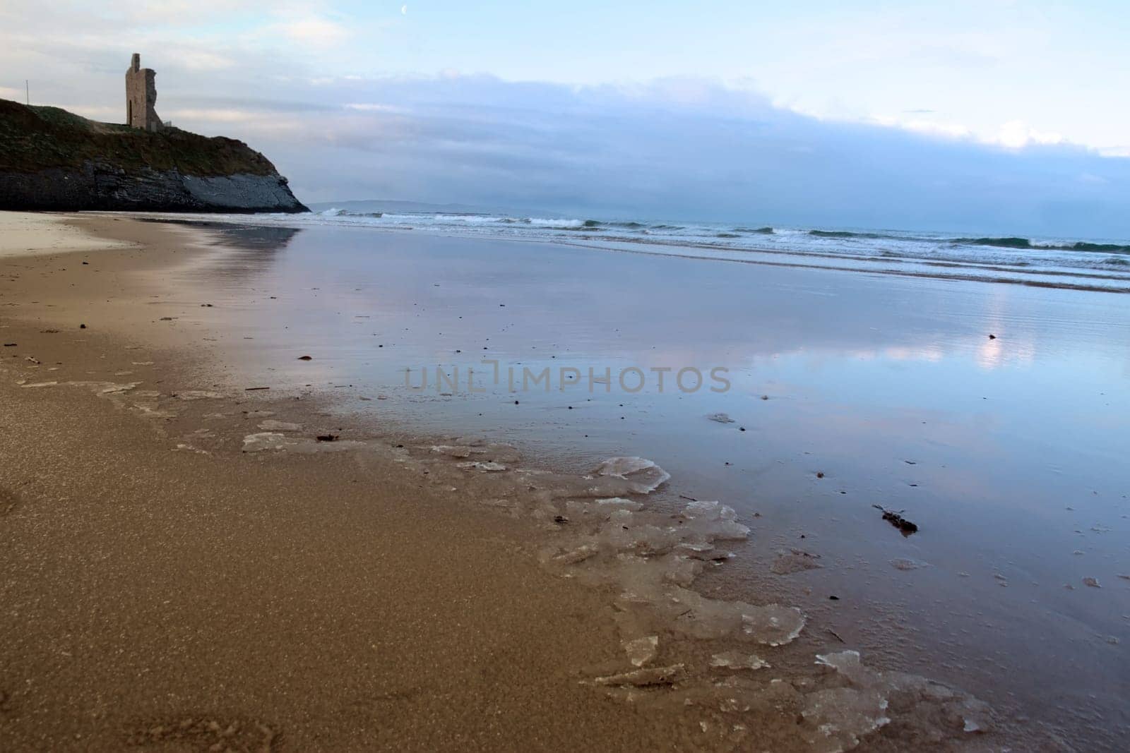 an icy beach view of the castle overlooking the beach in ballybunion co kerry ireland