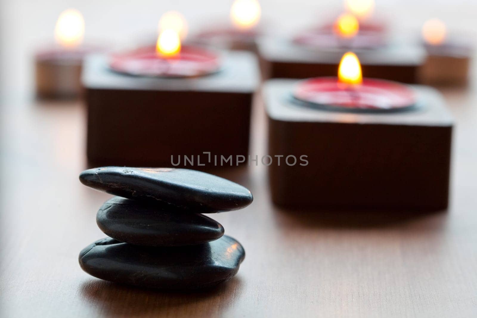 Close-up of black stones and candles in the background