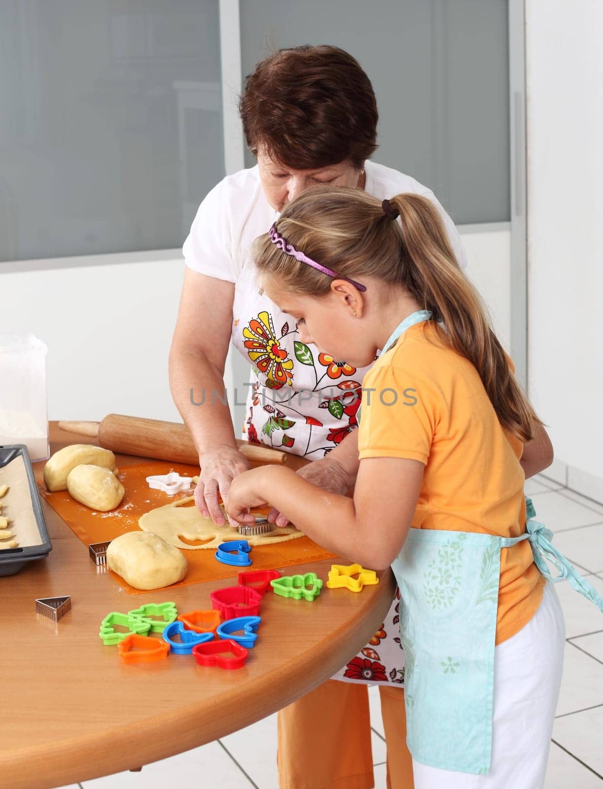Child and senior woman cutting pastry for Christmas