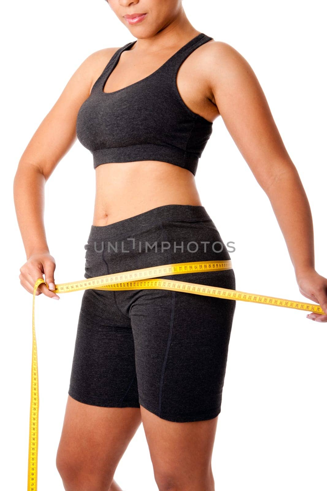Woman dressed in grey measuring size of thigh, healthy lifestyles weightloss concept, isolated.