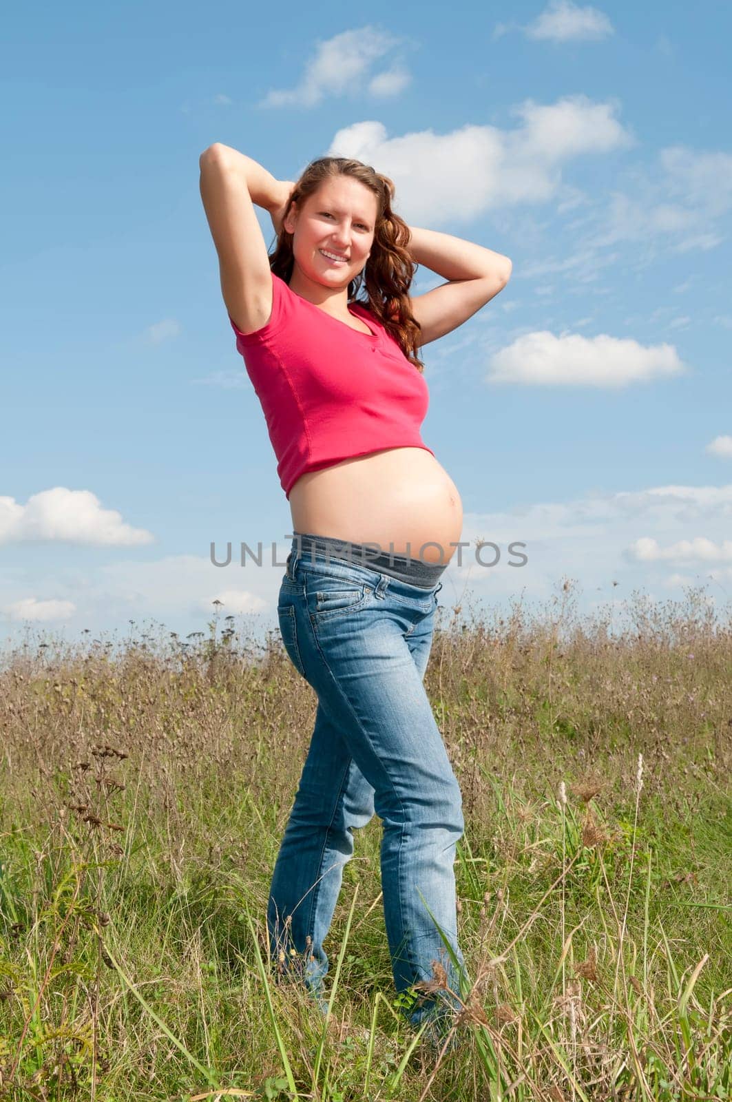 Pregnant young woman on a meadow