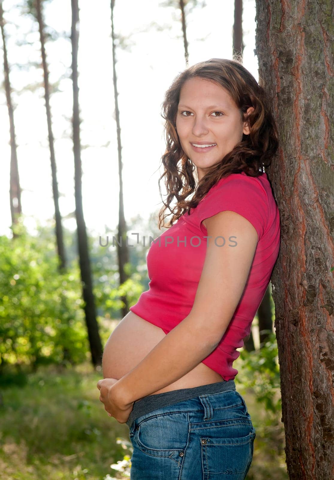 Pregnant young woman in the forest