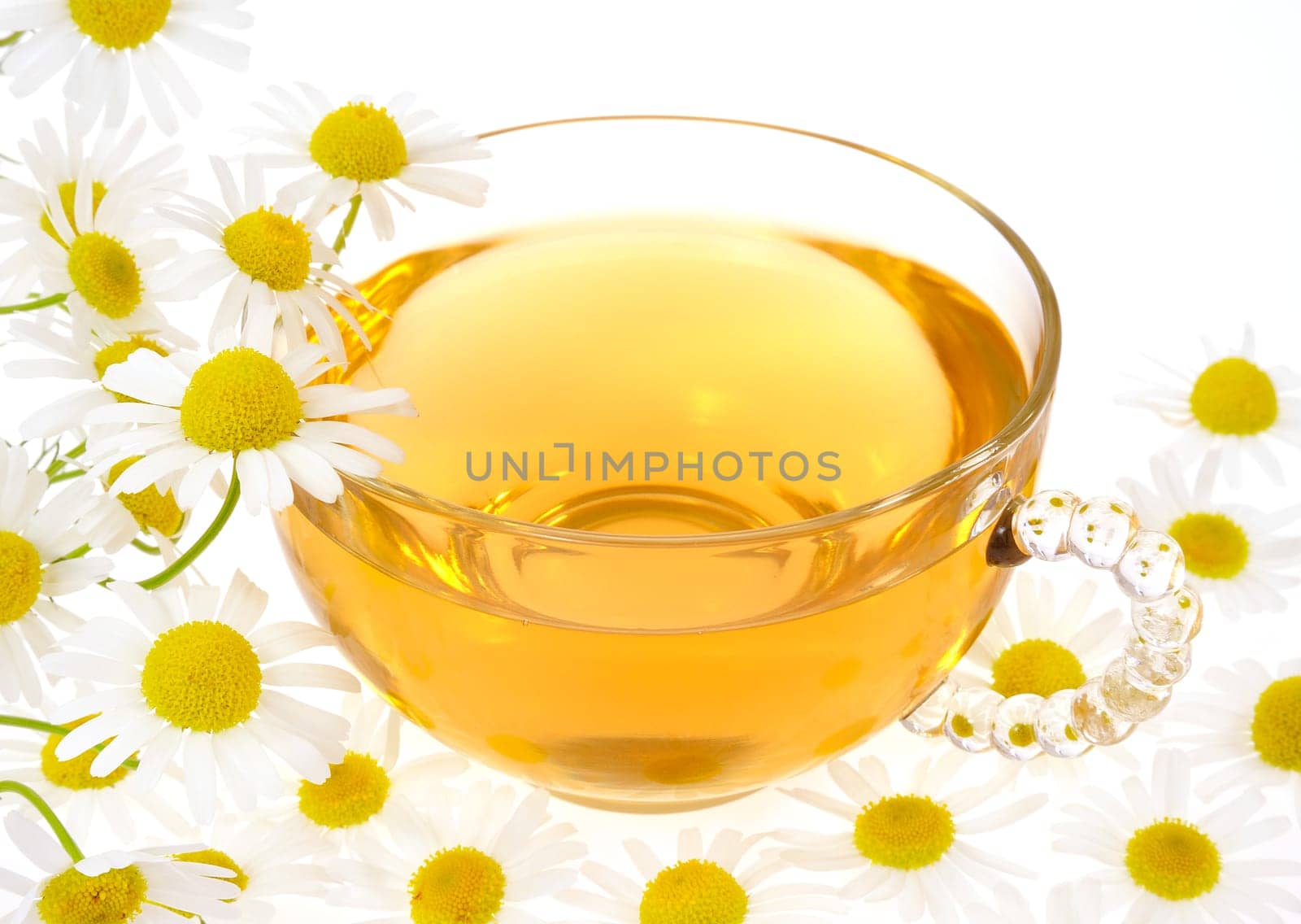 Cup of chamomile tea over white background