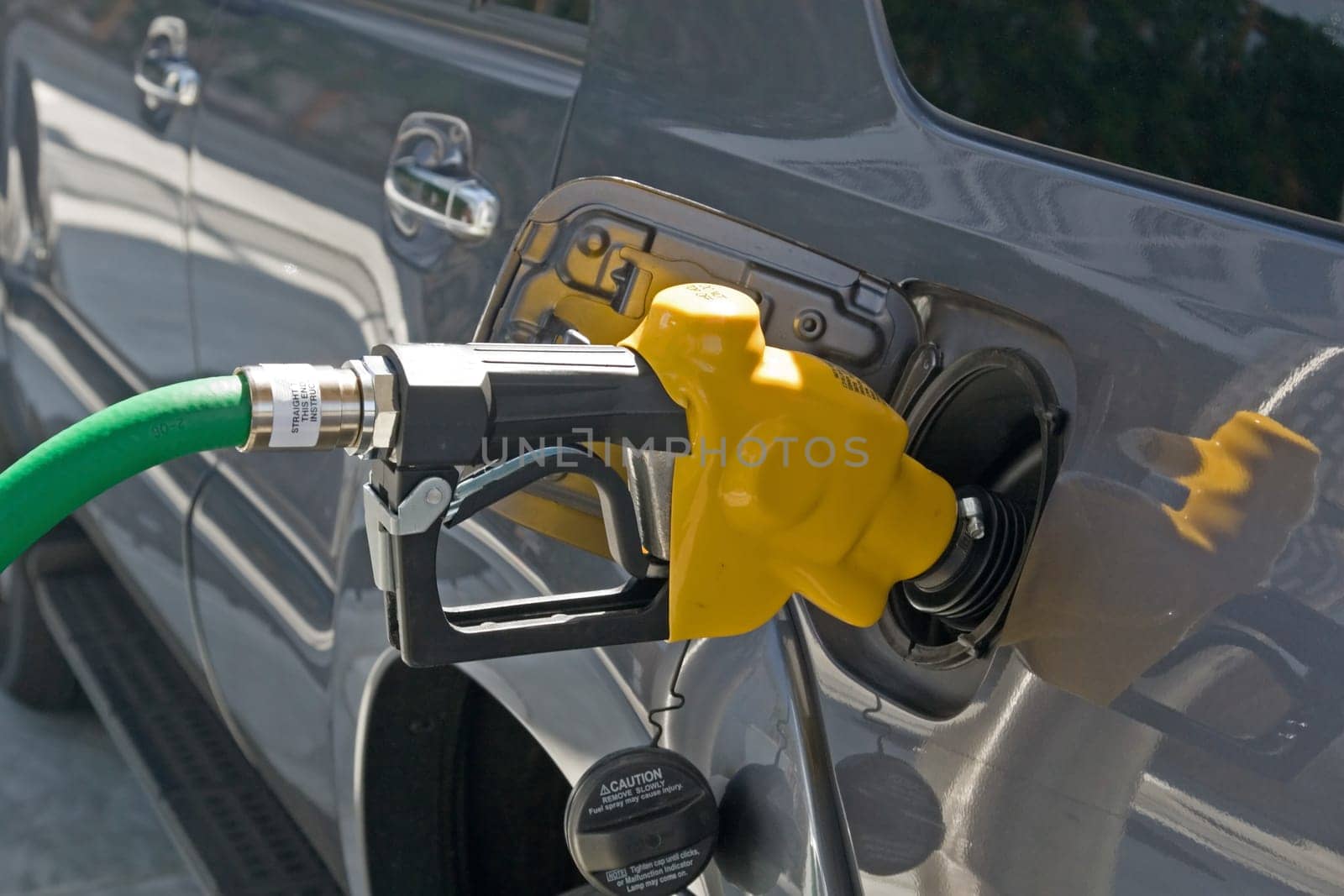 A gasoline station filling nozzle in a gas tank