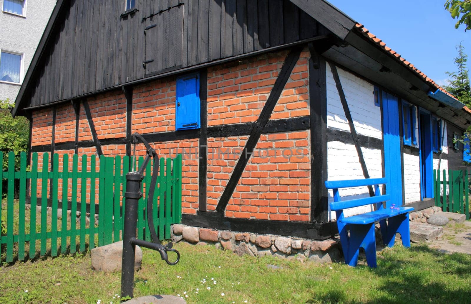 Timber framed traditional fisherman&#039 s house and a garden with water pump