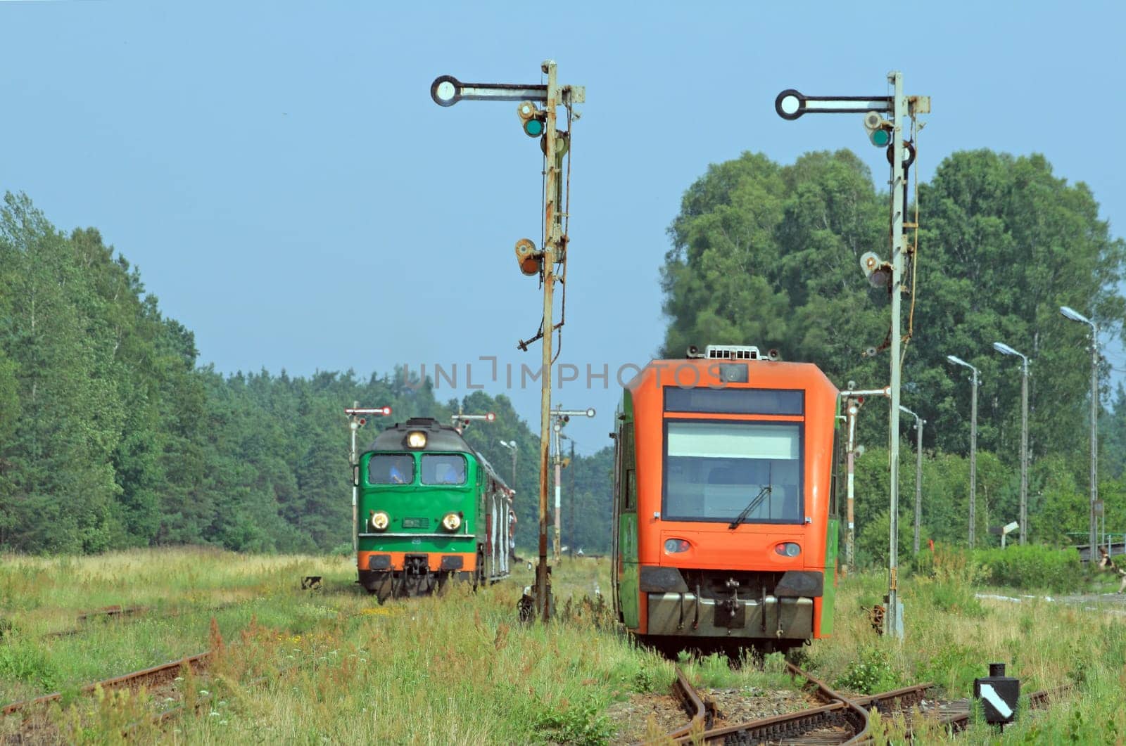 Diesel locomotive and light railbus crossing at the station
