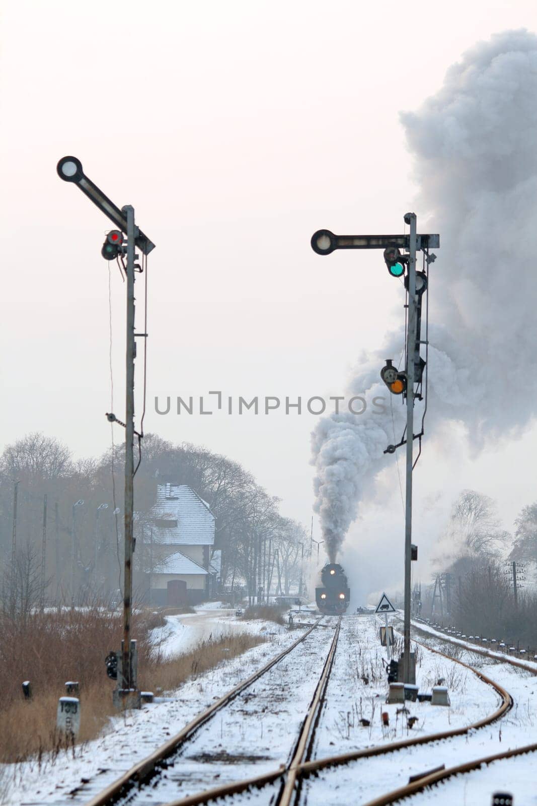 Old retro steam train starting from the station during wintertime
