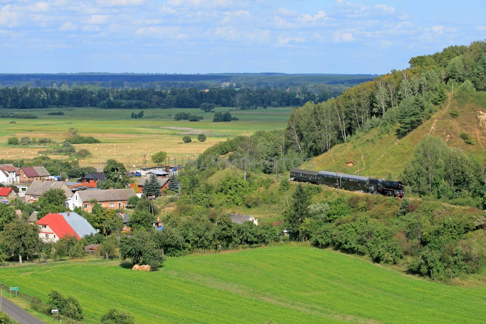 Beautiful hilly landscape with an old retro steam train
