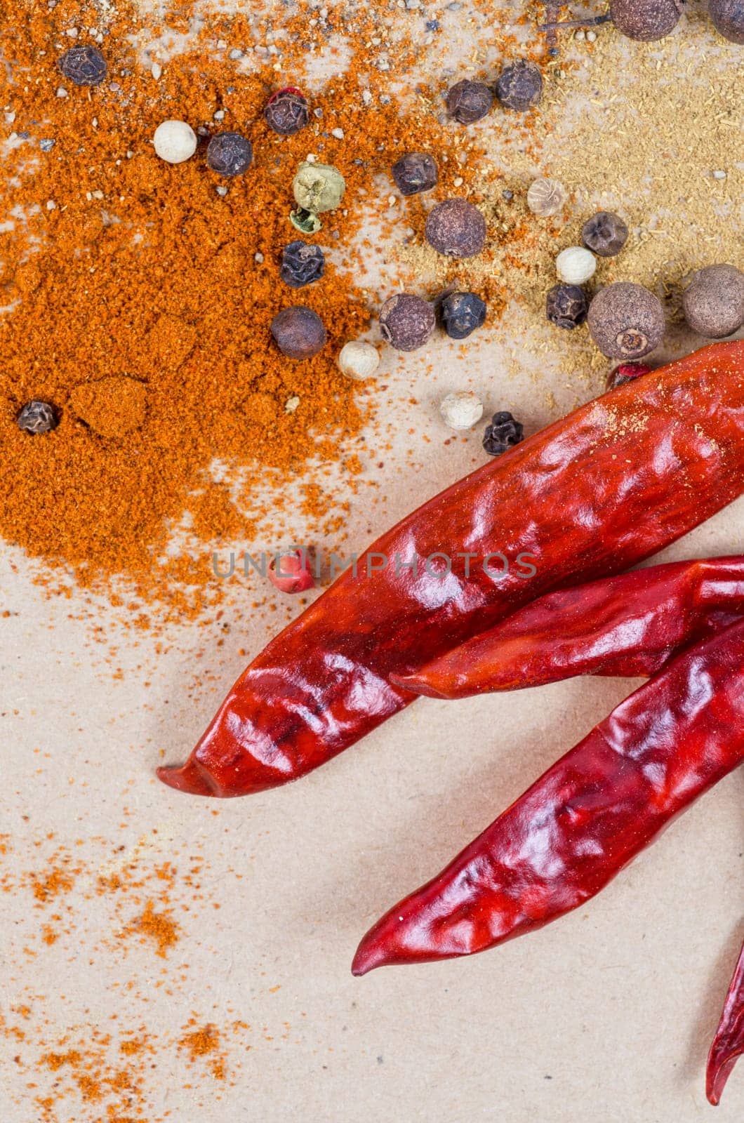 dried peppers and other kind of peppers spices on a brown background