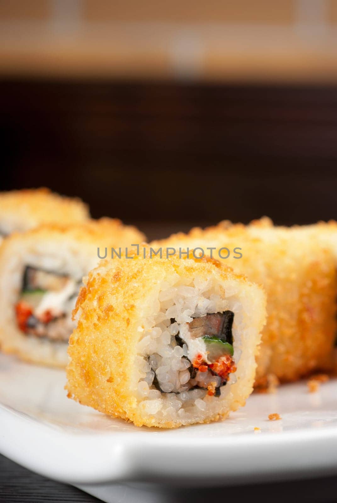 Sushi rolls made of rice, smoked eel, cream cheese and flying fish roe - tobiko caviar