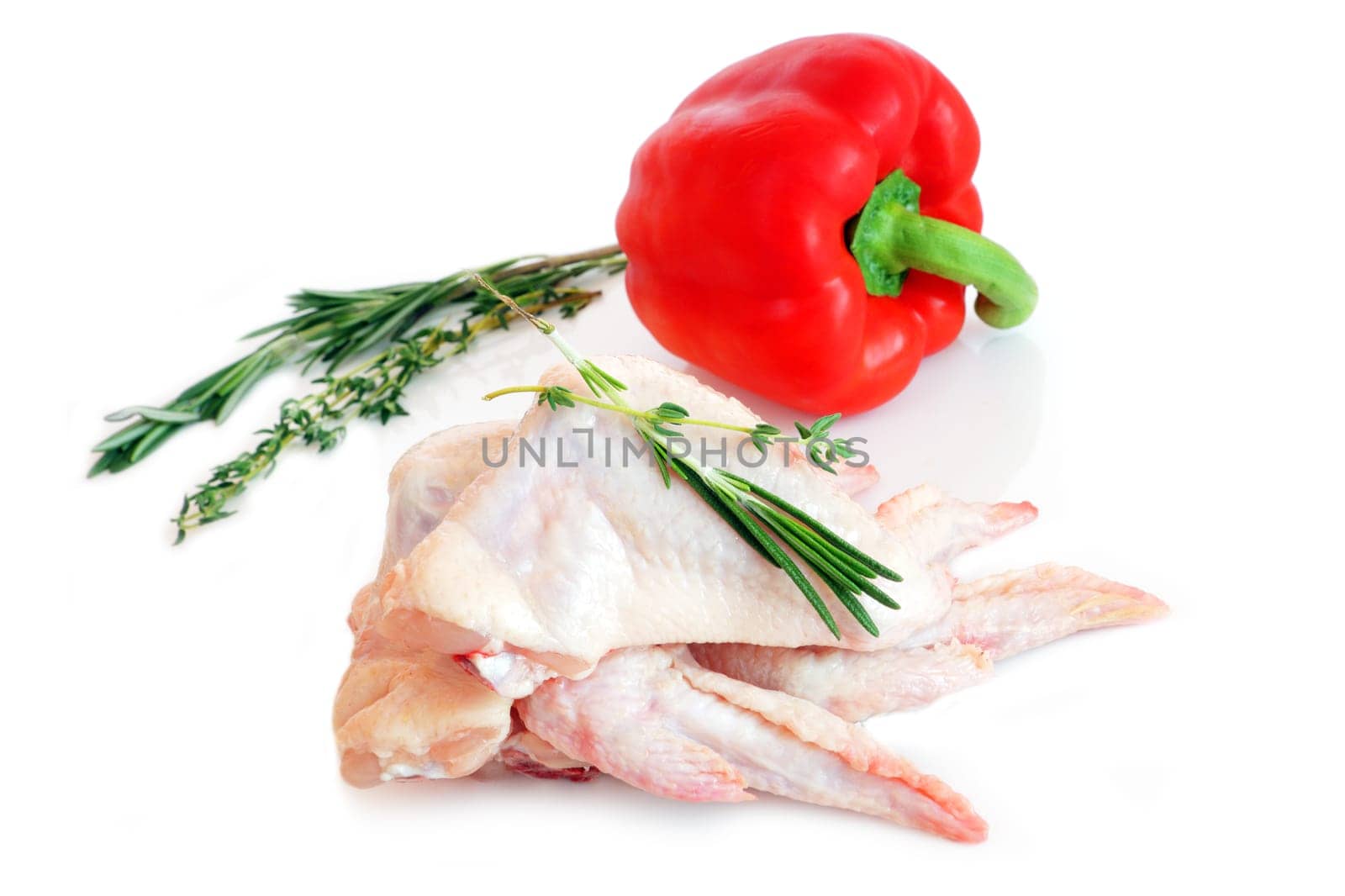 raw chicken wings with rosemary and red pepper on white background