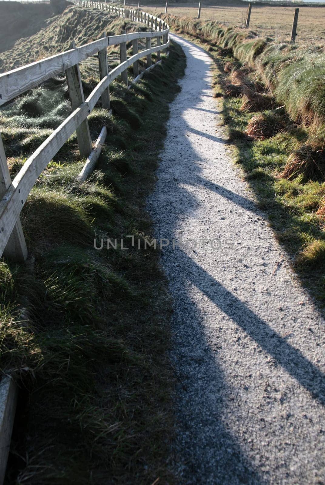 frosty winters view at ballybunion cliffside walk with atlantic view and fence shadows