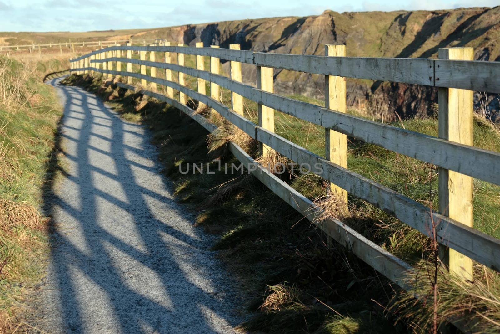frosty winters view at ballybunion cliffside walk with atlantic view and fence shadows