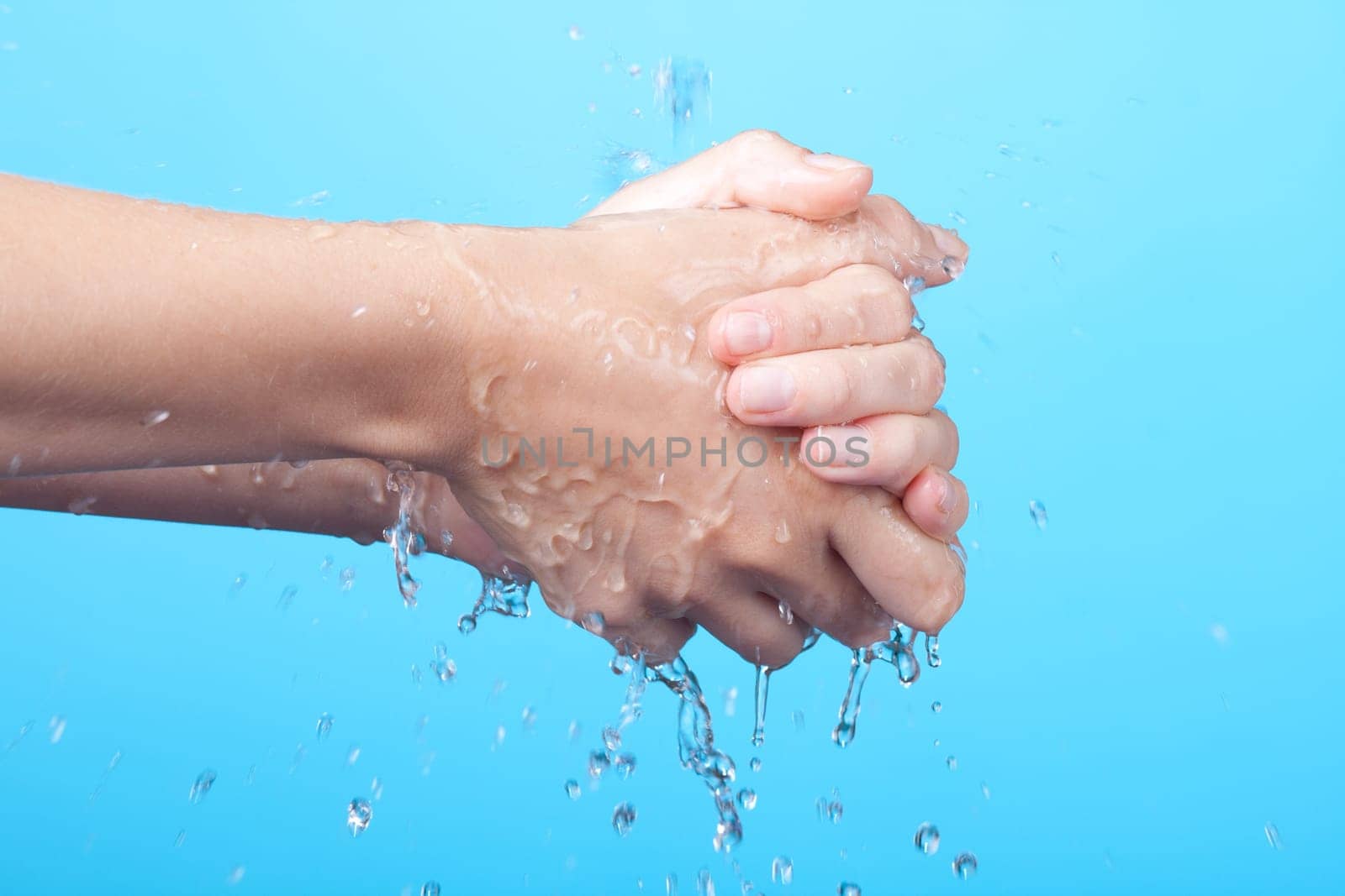 Woman washing her hands. Blue background.