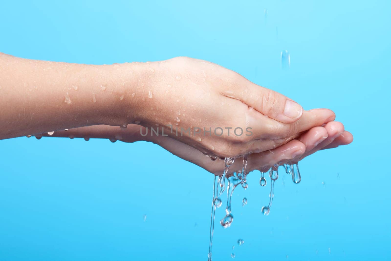 Woman washing her hands. Blue background.