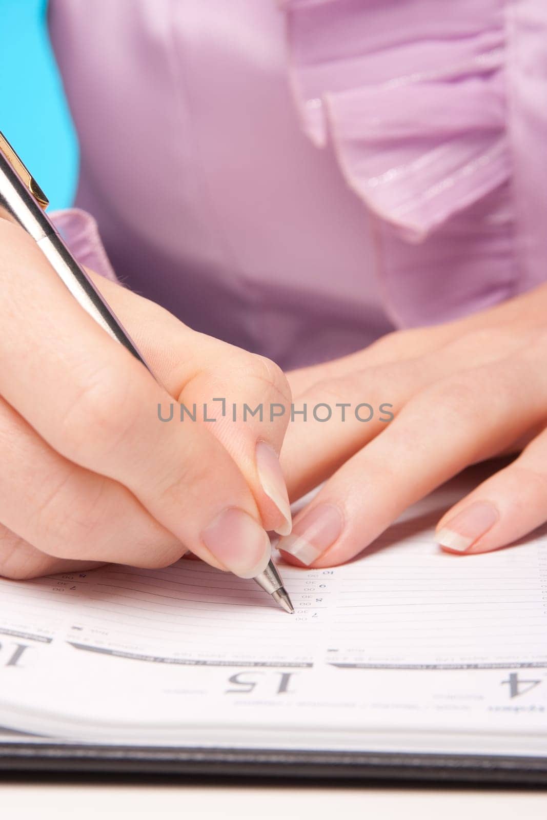 Woman make plans - hand with pen take a note in calendar.