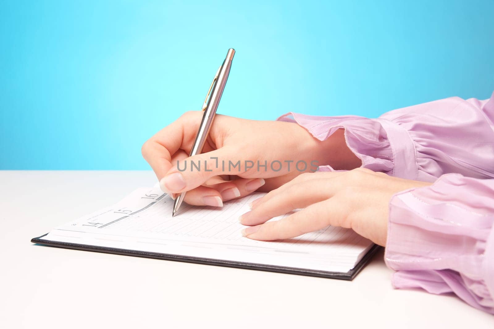 Woman make plans - hand with pen take a note in calendar.