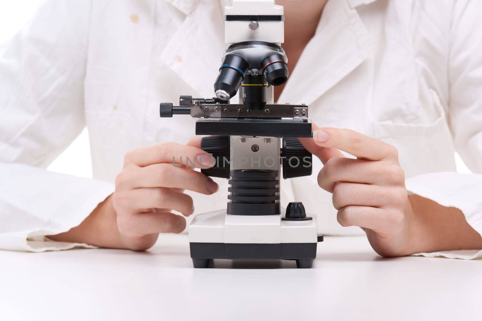 Female researcher with microscope. Focused on microscope and hands.
