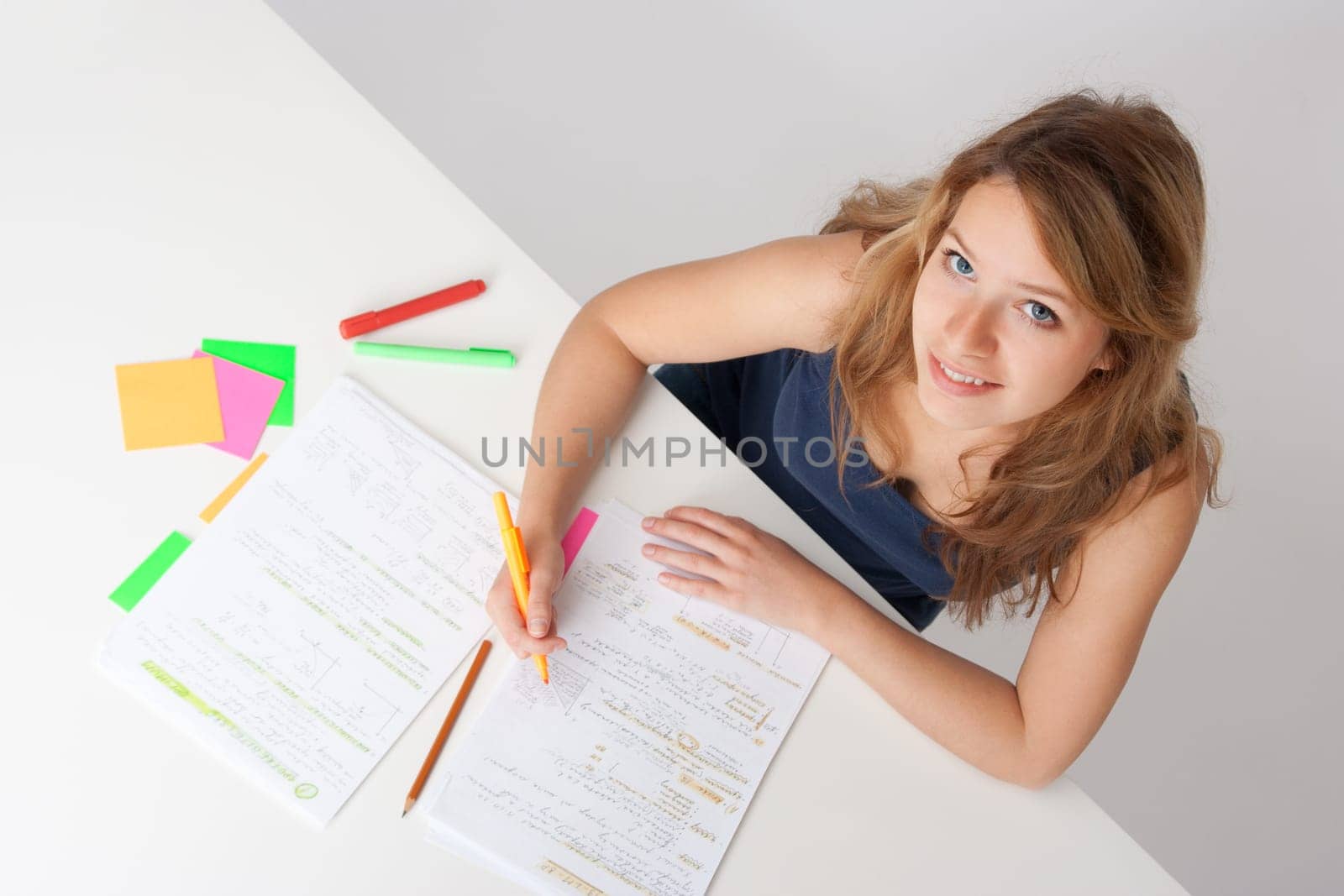 College student studying (swot up) for exam. Focused on face. Top view.