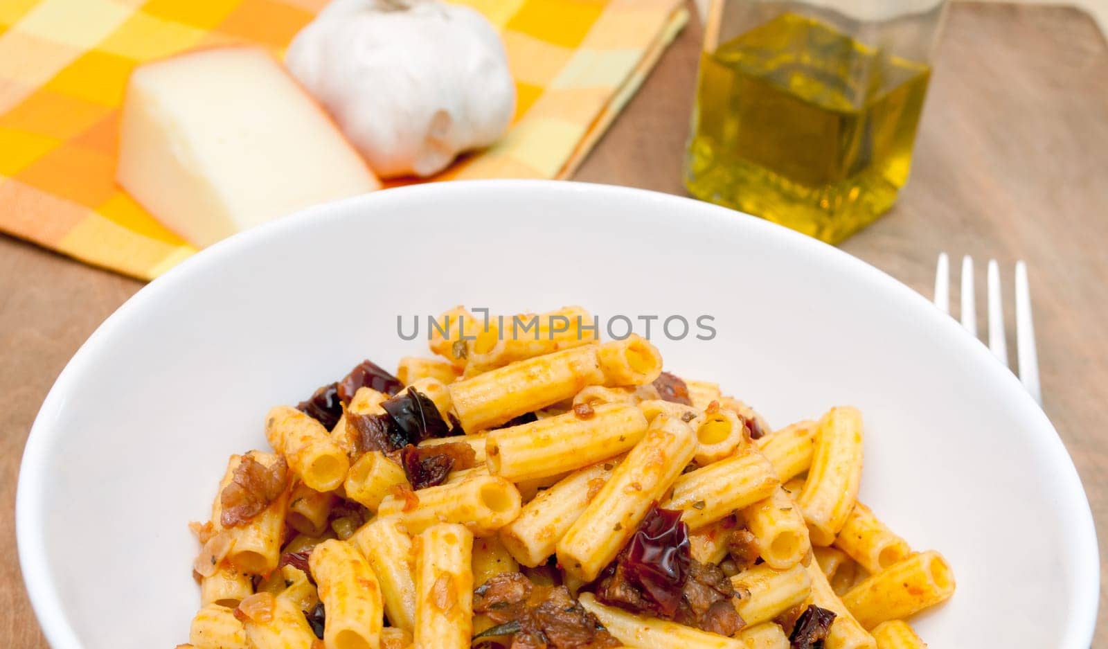 Plate of Penne Pasta With Dried Tomatoes on Wooden Table