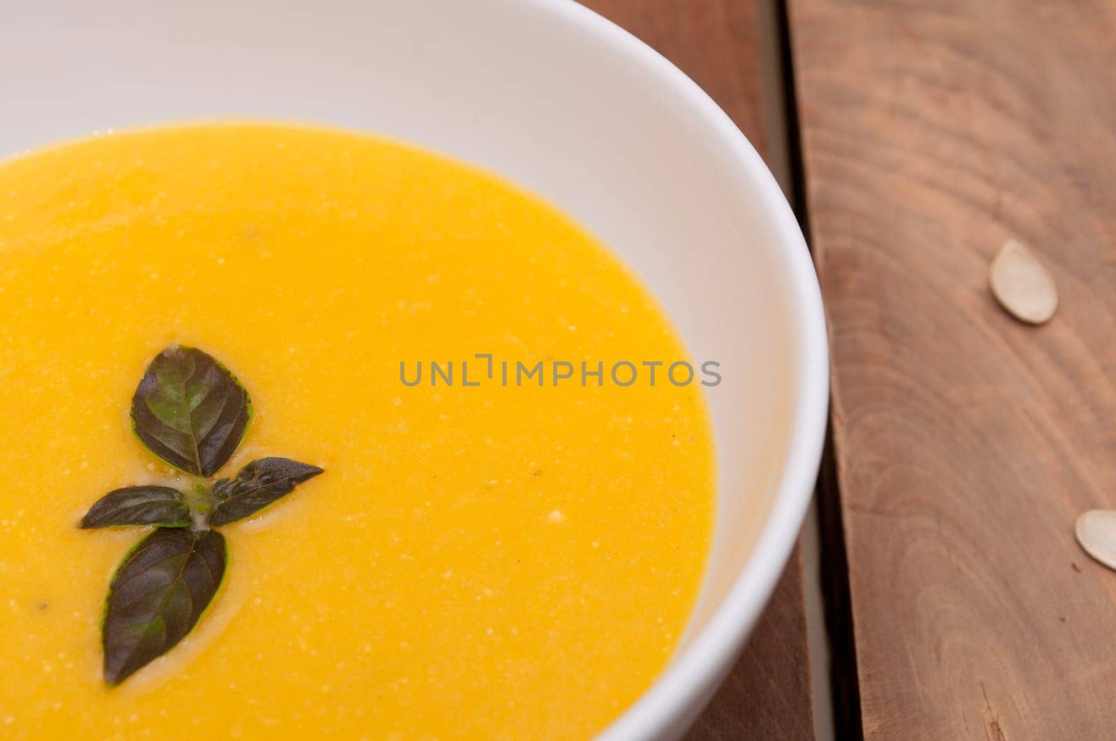 Bowl of Butternut Squash Soup on Old Wooden Table