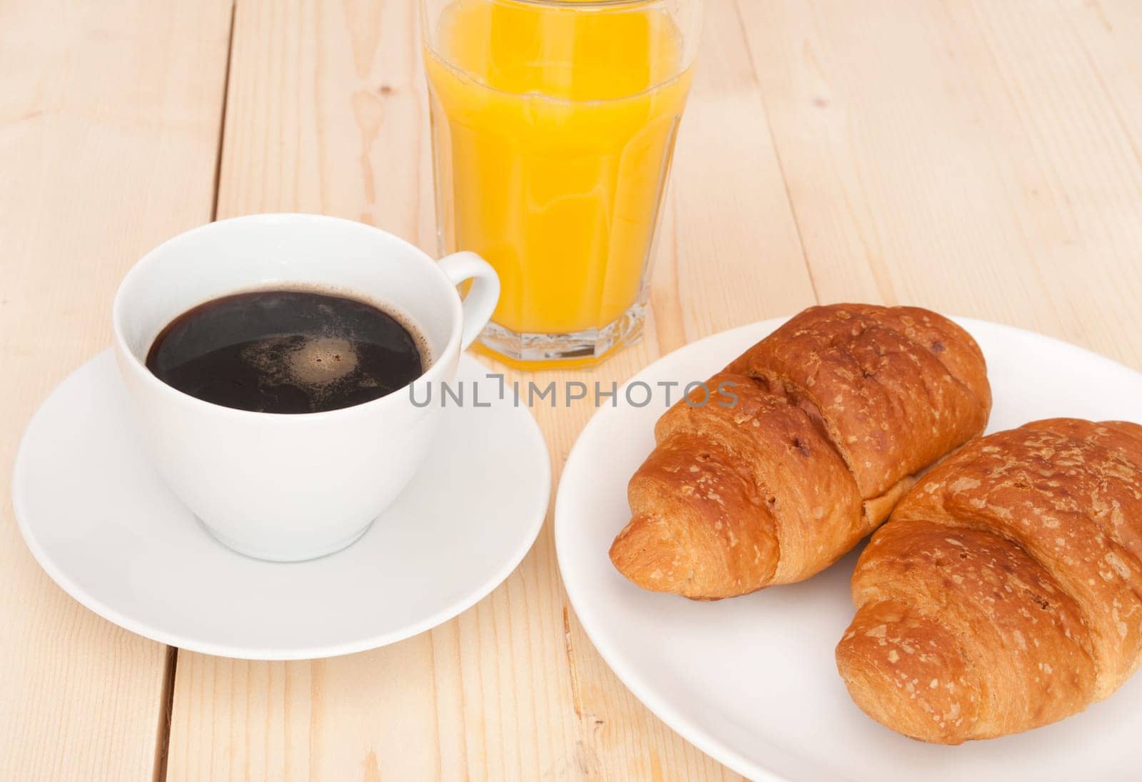 Breakfast - Croissants, Coffee and Orange Juice on Wooden Table