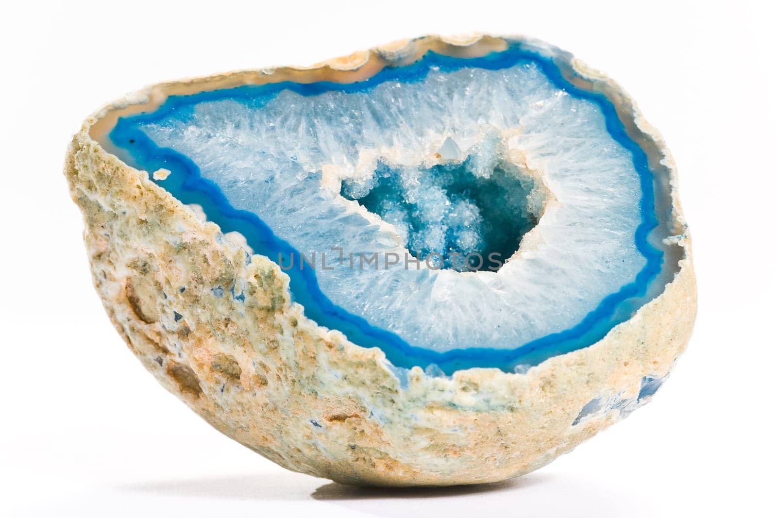 Piece of blue shiny agate with hole on white background