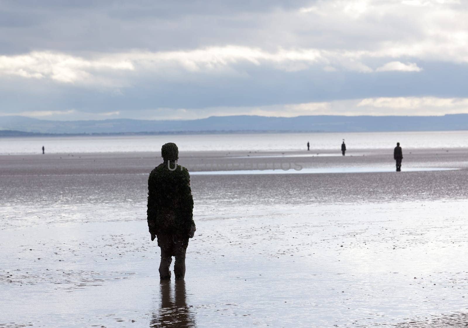 CROSBY BEACH, ENGLAND - SEPTEMBER 24: Statues forming Another Place by Antony Gormley on Crosby Beach on September 24, 2011. The statues are slowly rusting away with the tides and wind.