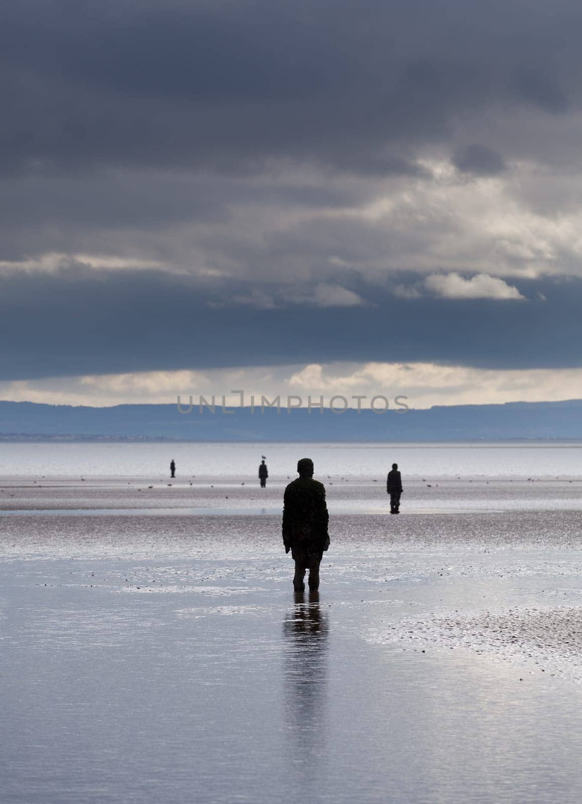 CROSBY BEACH, ENGLAND - SEPTEMBER 24: Statues forming Another Place by Antony Gormley on Crosby Beach on September 24, 2011. The statues are slowly rusting away with the tides and wind.