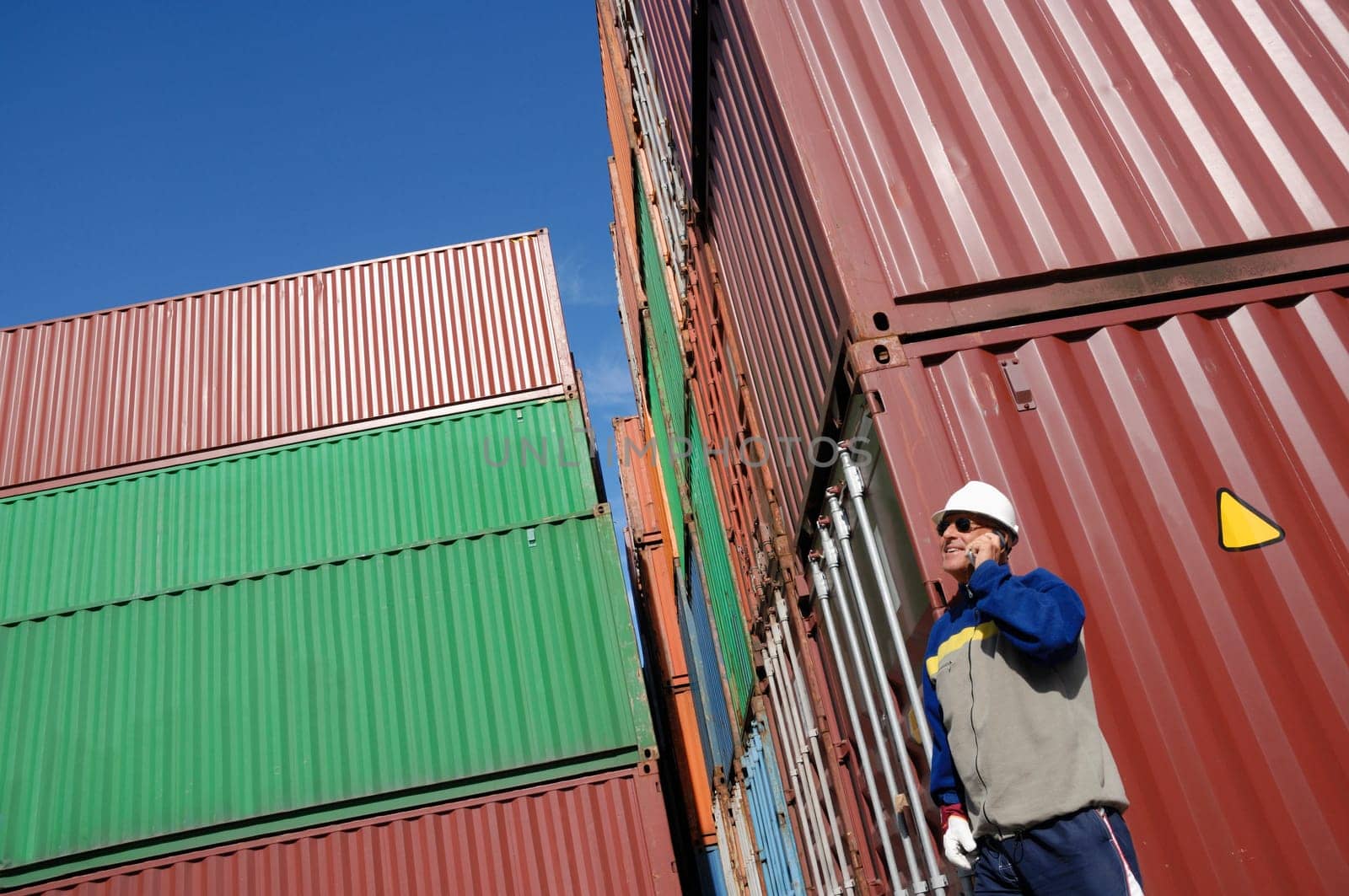 worker, dock-worker, with stacks of cargo-containers in background