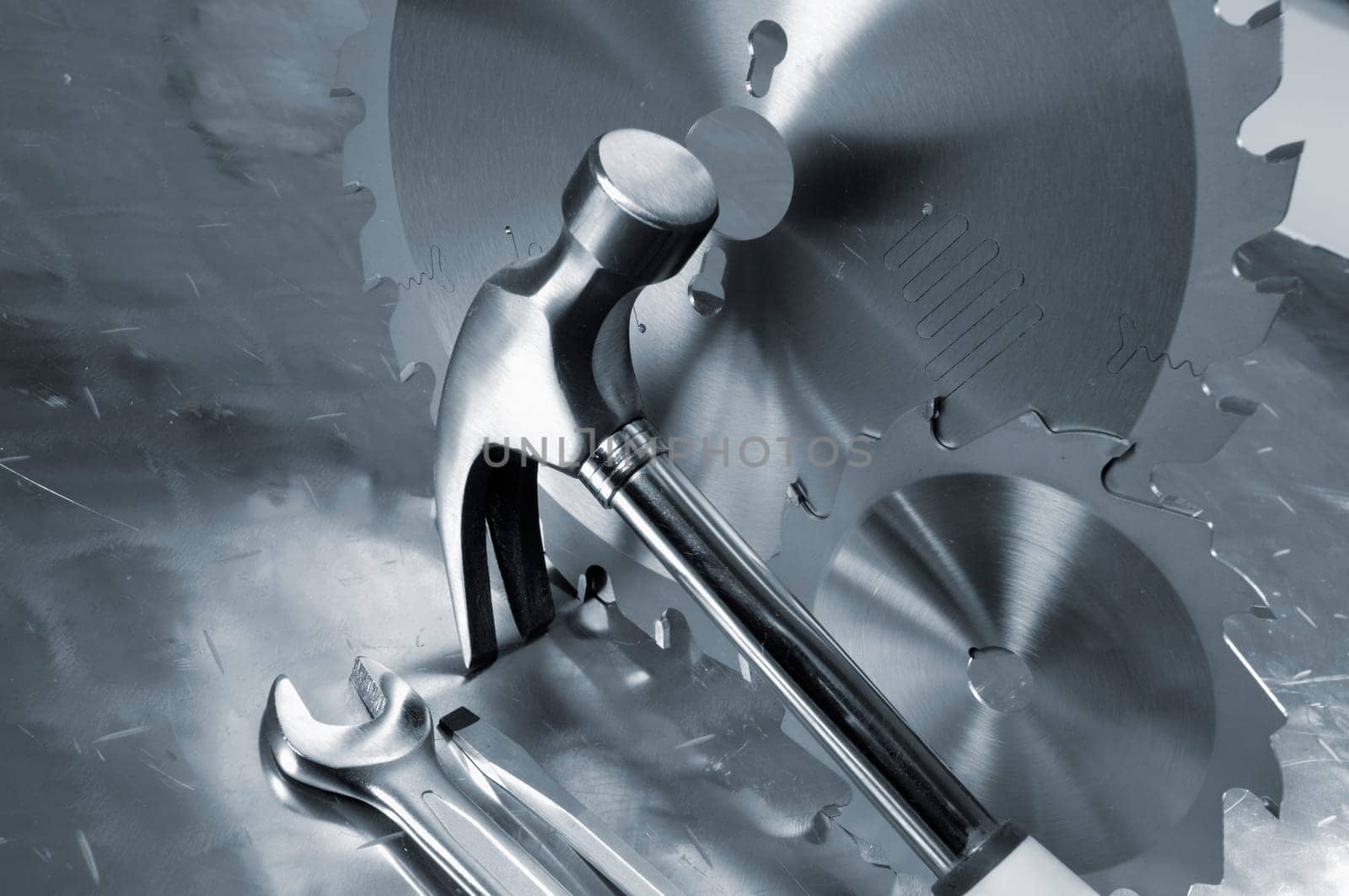 differant hand-tools, hammer, wrench, saw-blades, all in a blue toning concept