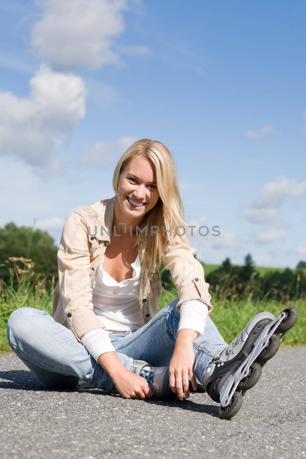 Inline skates young attractive woman wearing jeans sitting asphalt road