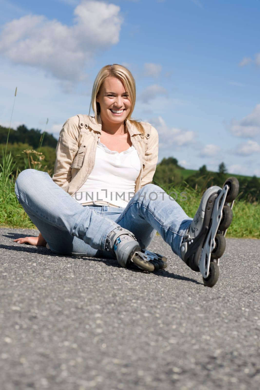Inline skates young attractive woman wearing jeans sitting asphalt road
