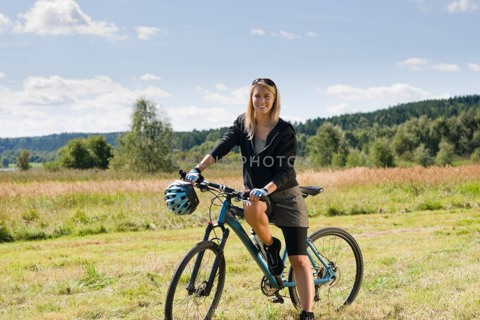 Mountain biking happy sportive girl relax in meadows sunny countryside