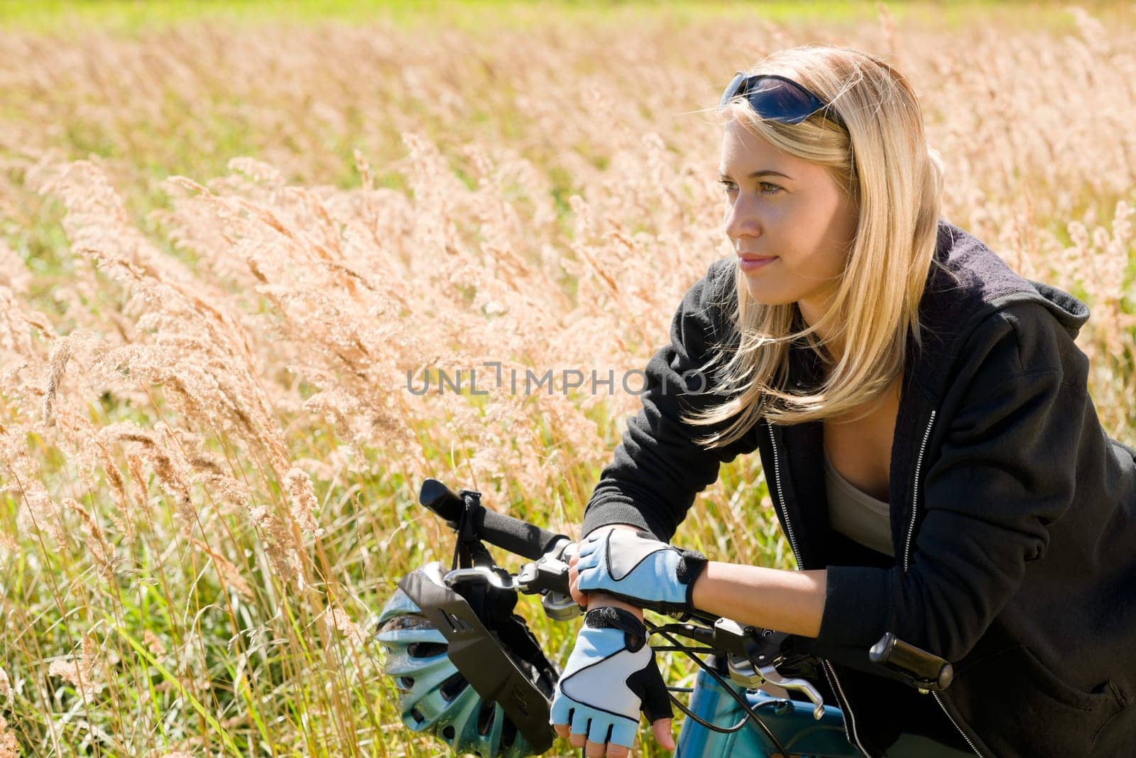 Mountain biking happy young woman relax in cornfield sunny countryside