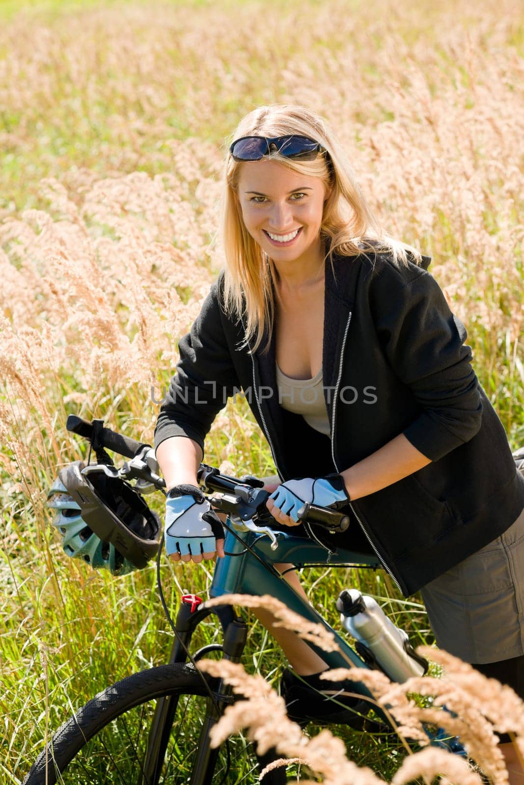 Mountain biking happy young woman relax in cornfield sunny countryside