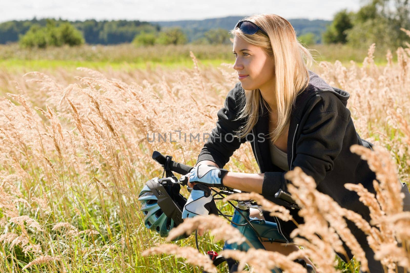 Mountain biking happy young woman relax in cornfield sunny countryside