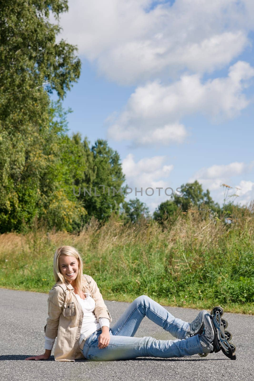 Inline skates young attractive woman wearing jeans sitting asphalt road