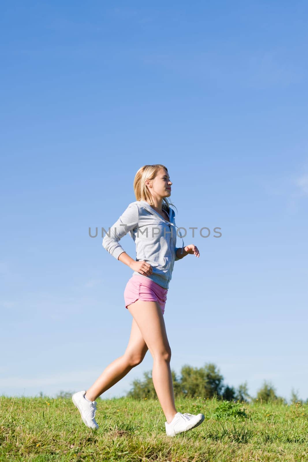 Sportive jogging young happy woman meadows blue summer sky