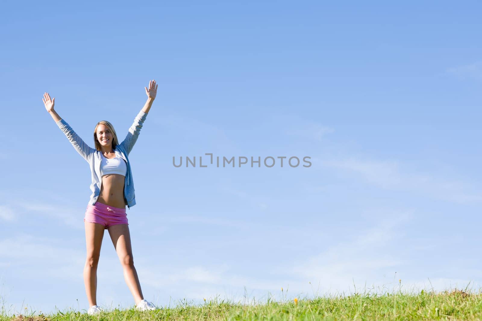 Sportive stretching young happy woman meadows blue summer sky